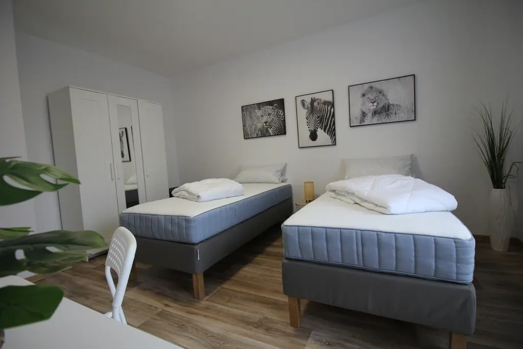 Schlafzimmer mit zwei Einzelbetten und Löwenbild