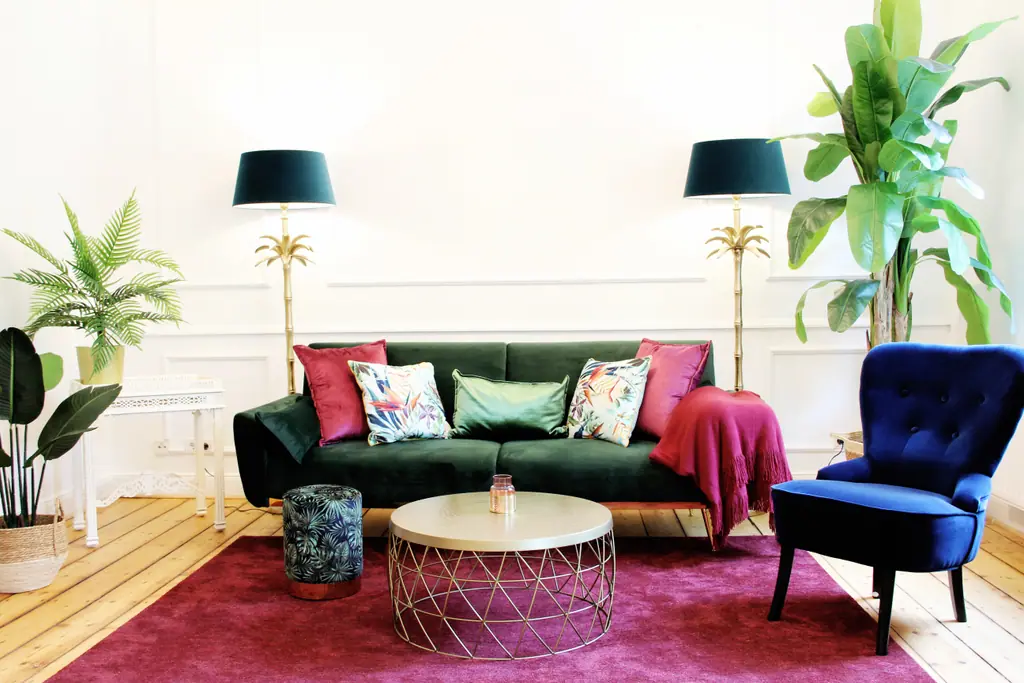 ARTstudios Group: Wohnzimmer des Tropical mit grünem Sofa und Palmen