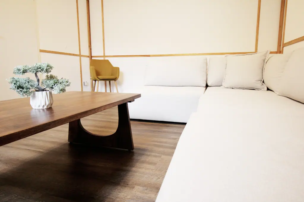 Asia Suite: Lounge mit niedrigem Holztisch, weißer Sitzlandschaft und Shoji-Wänden