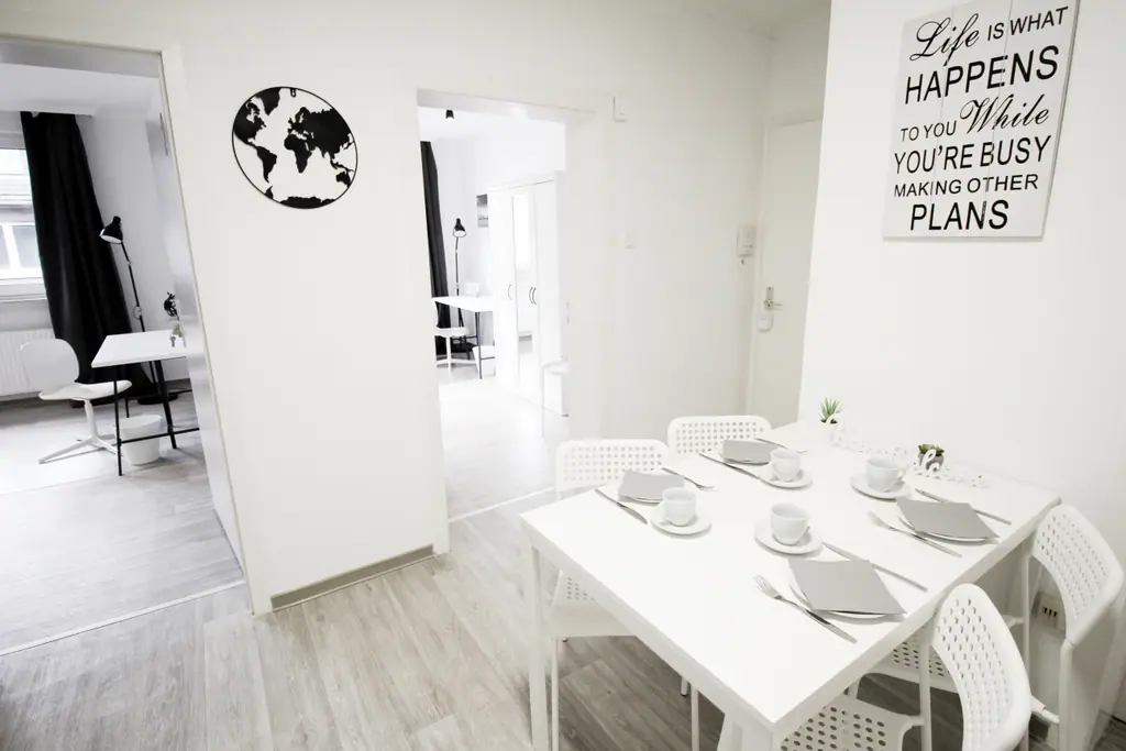 City Team Lodge: Essbereich mit weißem Tisch und Blick in die Küche