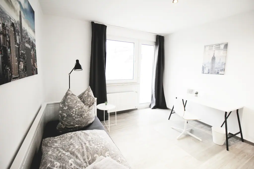 Schlafzimmer mit Bett, Fenster und Schreibtisch