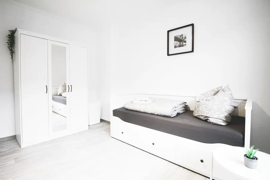 Schlafzimmer mit Einzelbett und Kleiderschrank