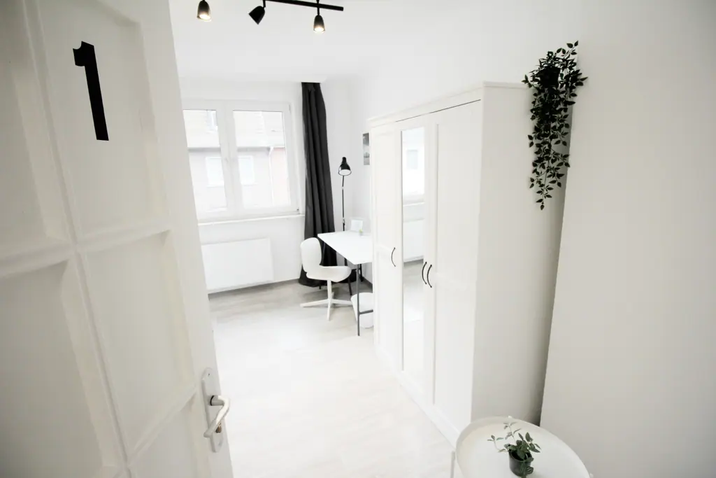 Zimmer 1 mit Kleiderschrank und Pflanze