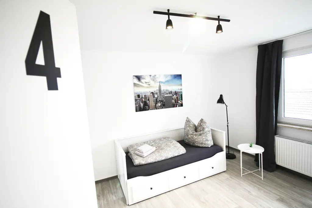 Zimmer 4 mit Bett und Stadtbild