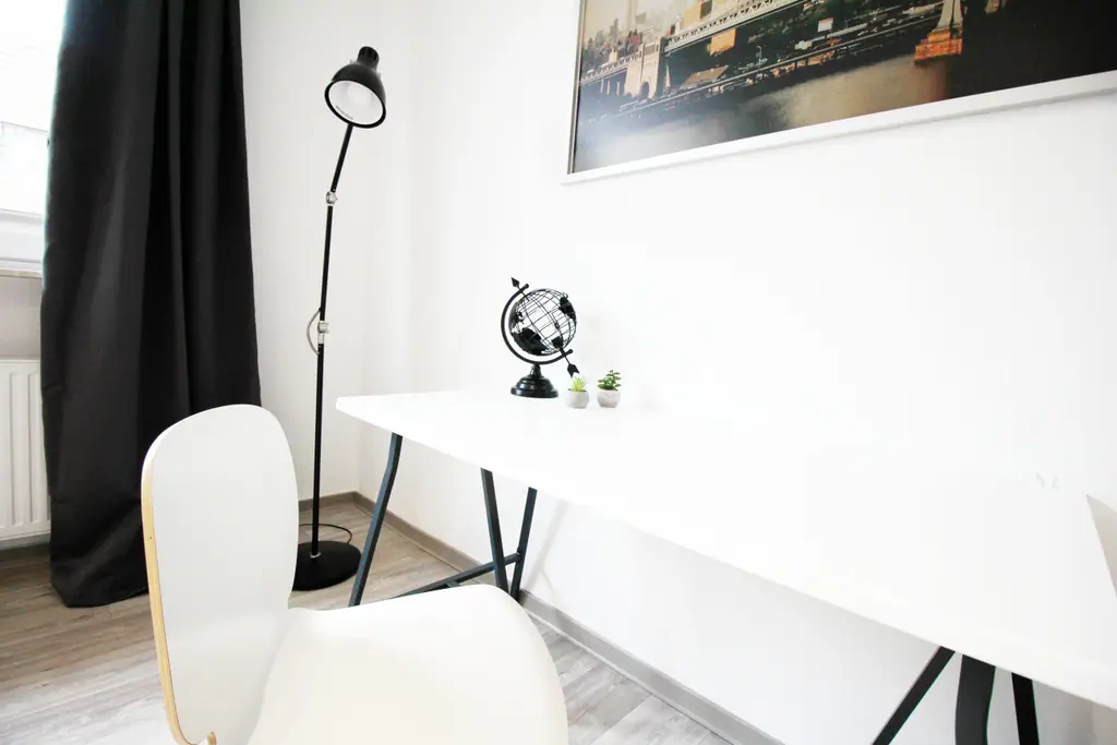 Weißer Schreibtisch mit Globus und Lampe