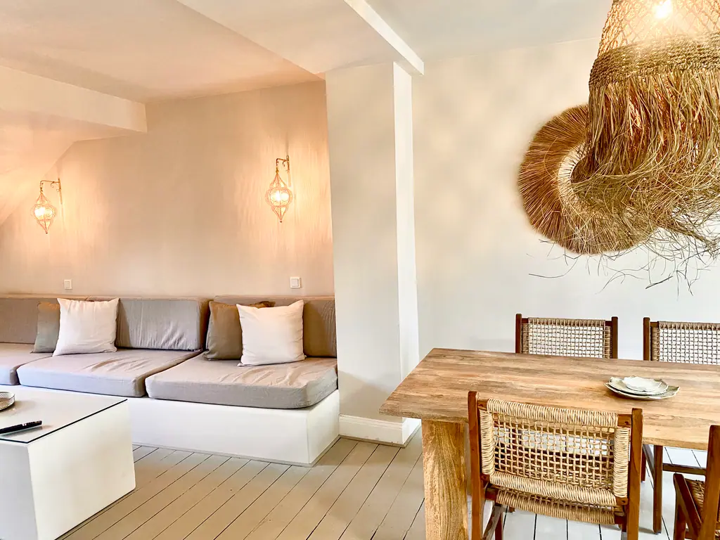 Desert SPA Lounge: beige Sitzlandschaft, Rattanlampe und Esstisch unter dem Dach