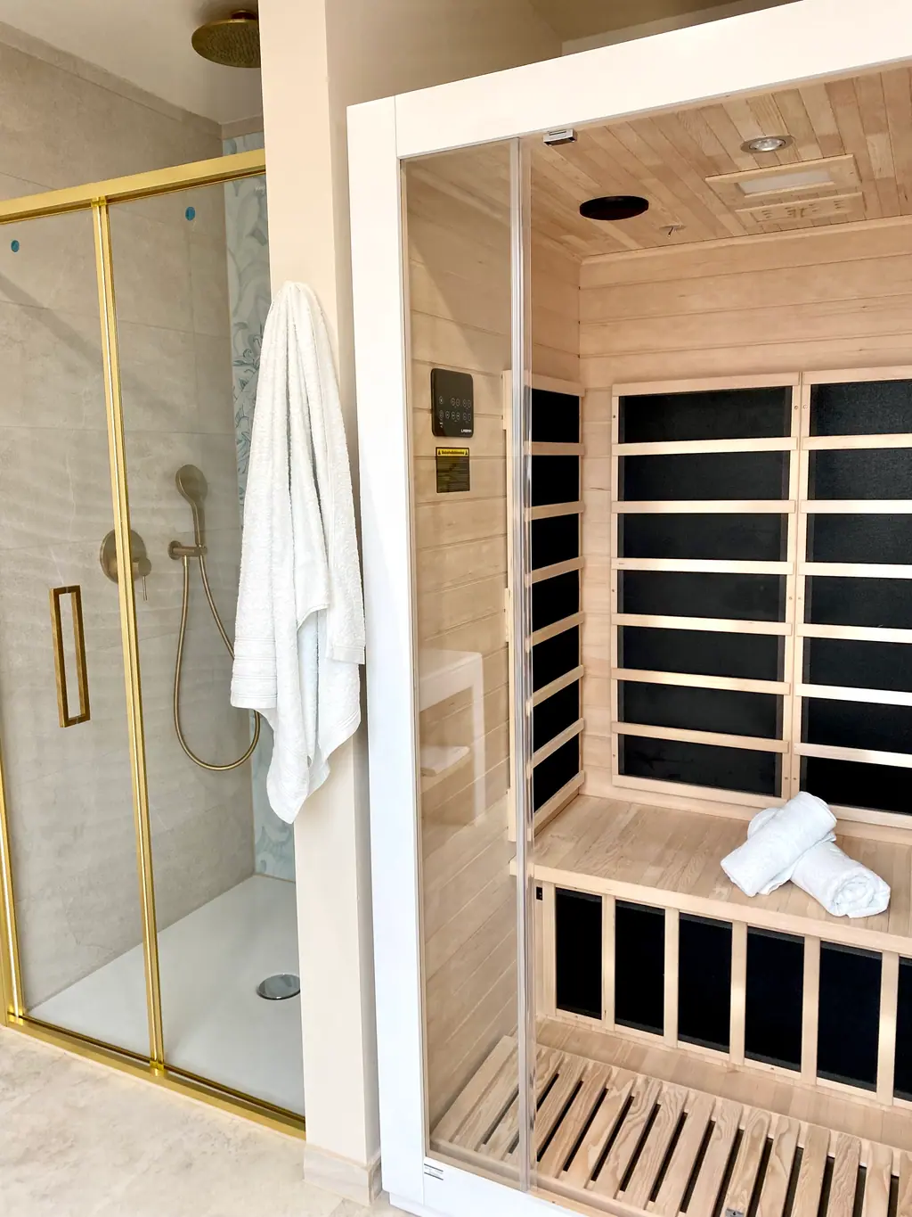 Private Infrarotsauna neben der Dusche mit goldenen Armaturen
