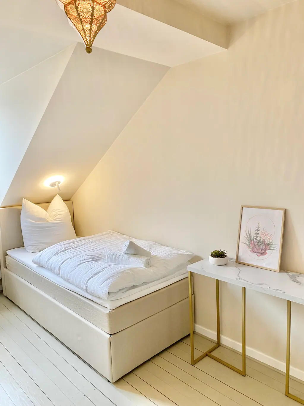 Bett unter der Dachschräge mit Marmor-Nachttisch