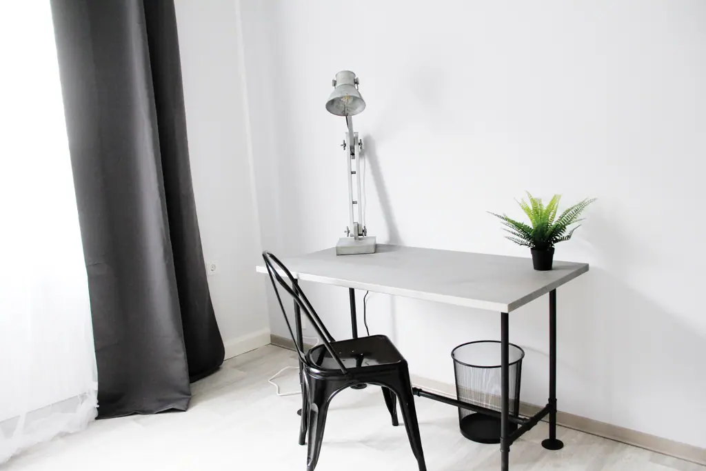 Schreibtisch mit Metallstuhl und Lampe