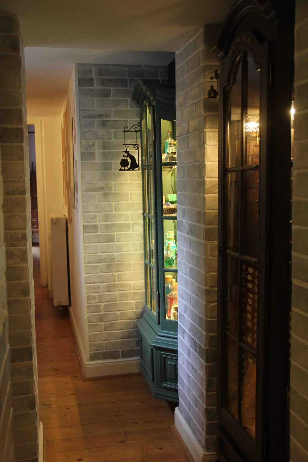 Magische Gasse: Flur mit grauem Backstein und beleuchteten Schaufenster-Vitrinen