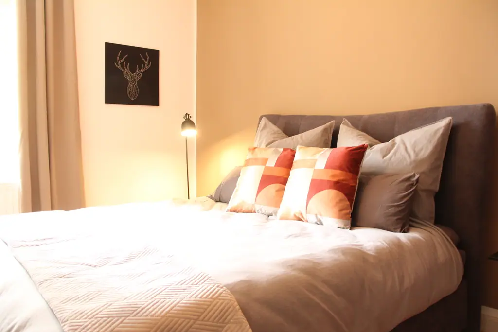 Zweites Schlafzimmer in Beige mit Hirschbild und Kissen