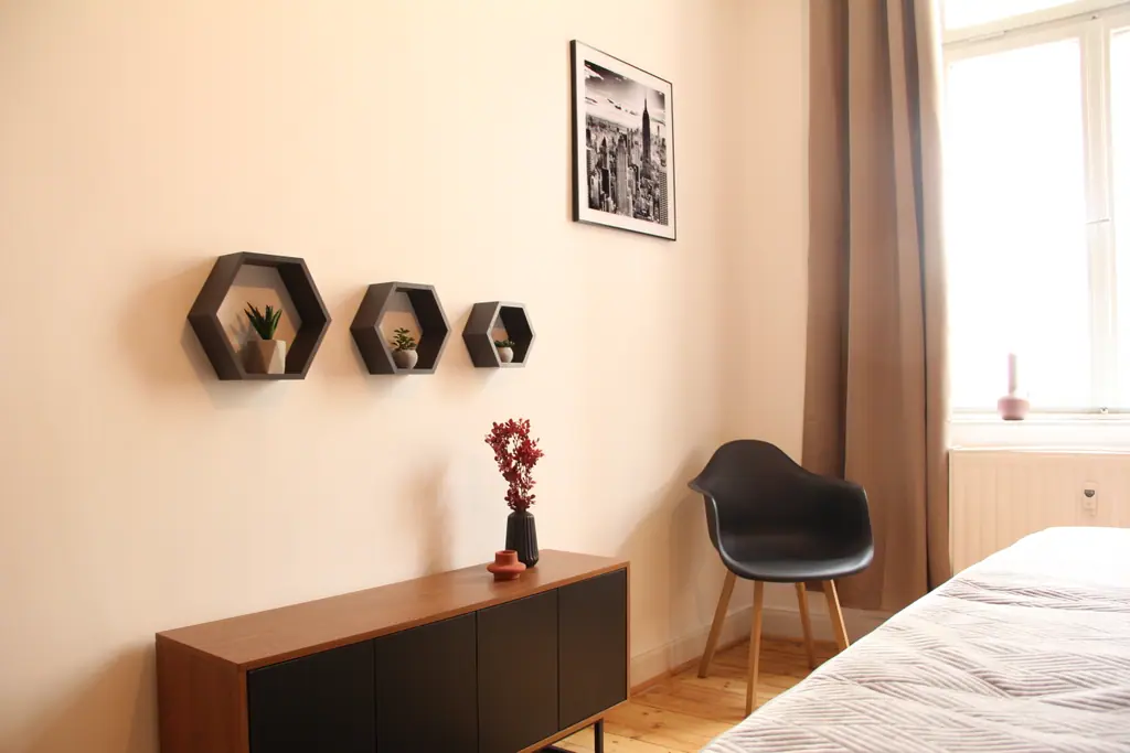 Sideboard mit Wabenregalen und Sessel im zweiten Schlafzimmer