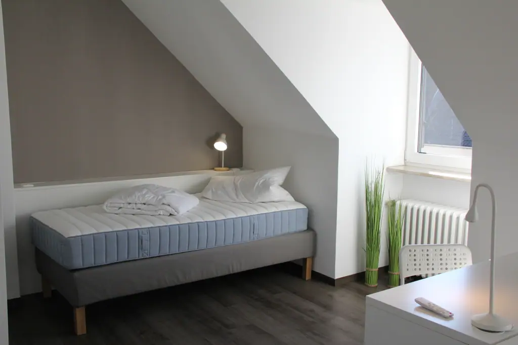 Einzelbett unter der Dachschräge mit Fenster