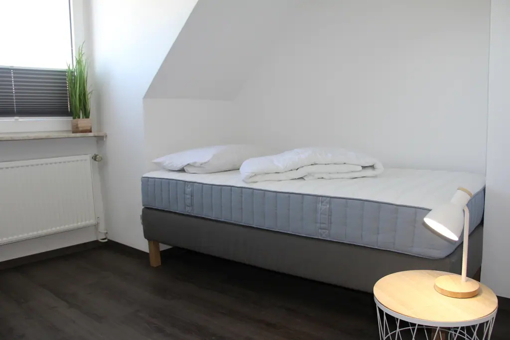 Schlafzimmer mit Einzelbett und Beistelltisch