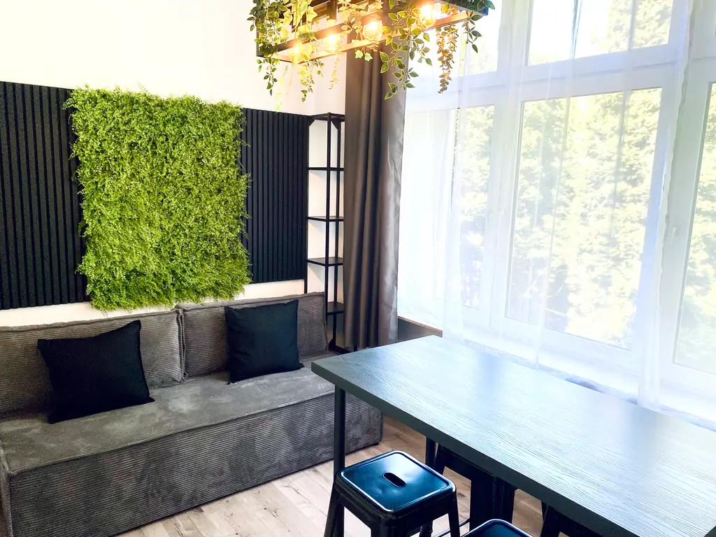 Lounge mit Mooswand, Sofa und Hochtisch