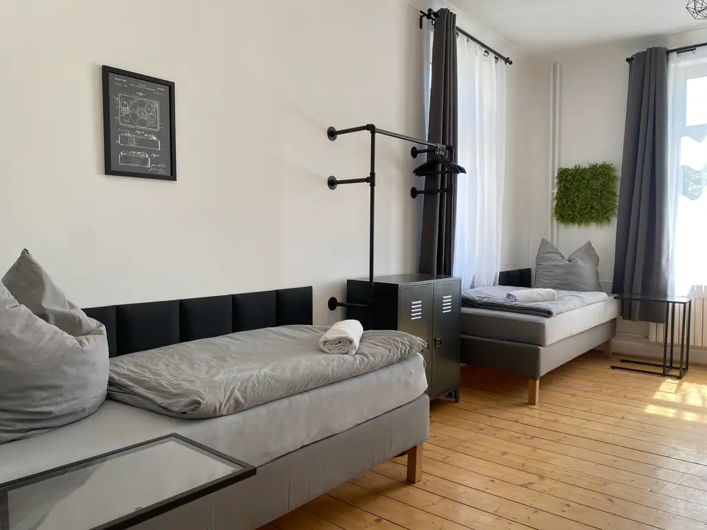Schlafzimmer mit Kleiderstange und Spind