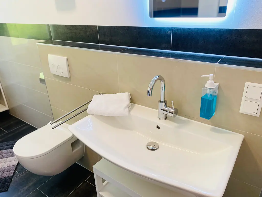 Bad mit beleuchtetem Spiegel und Waschbecken