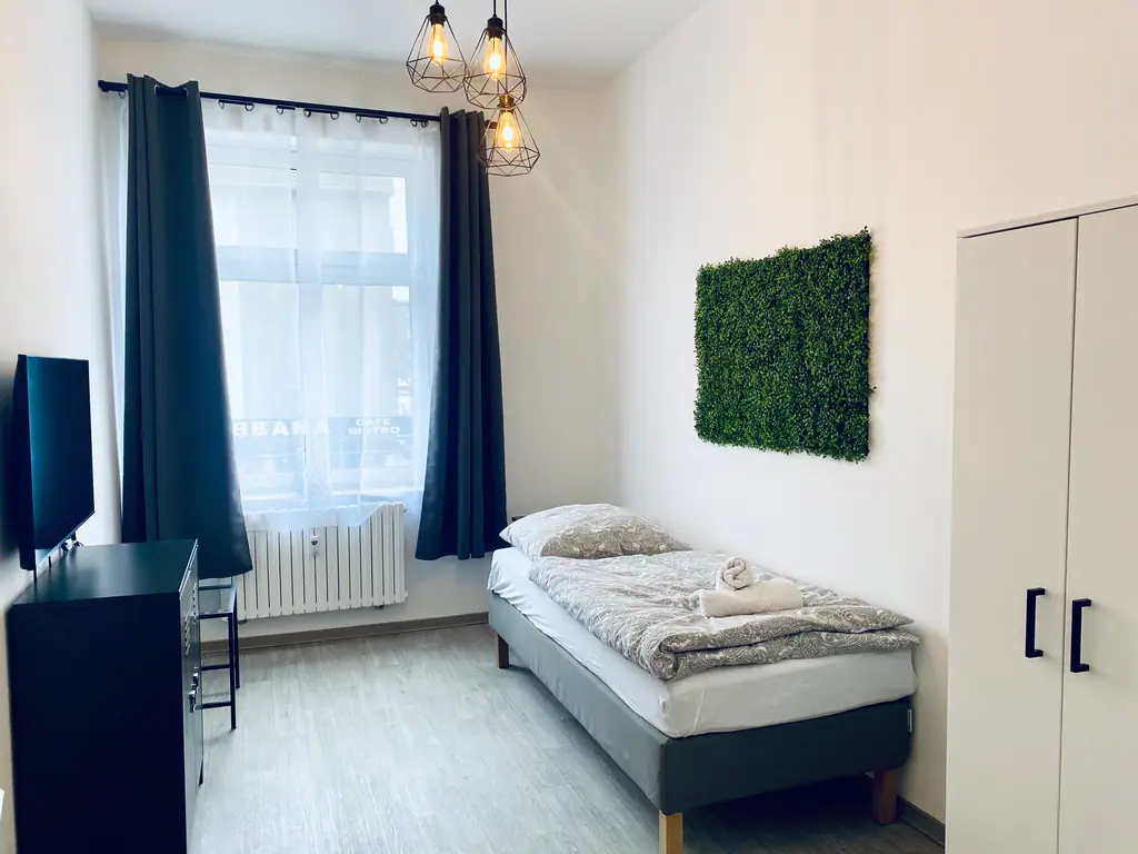 Schlafzimmer mit Einzelbett und Mooswand