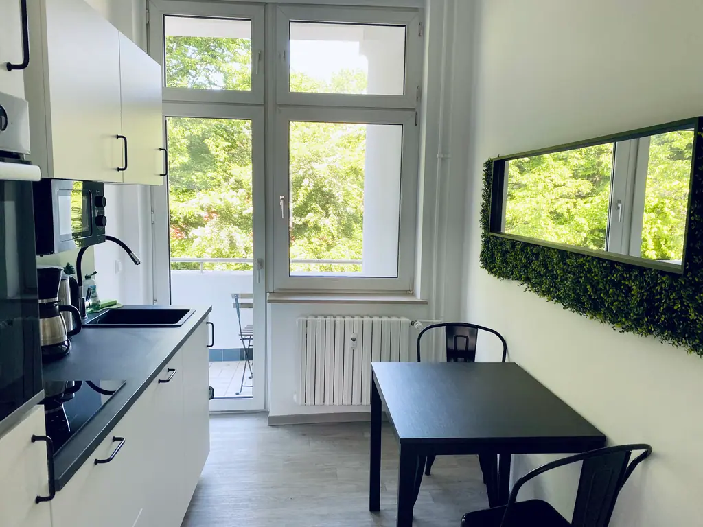 Küche mit Essplatz und Blick auf den Balkon