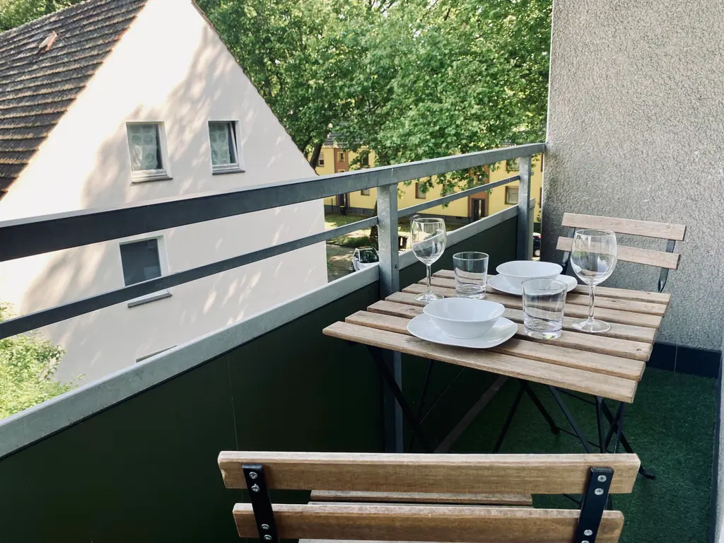 Balkon mit Klapptisch und Stühlen