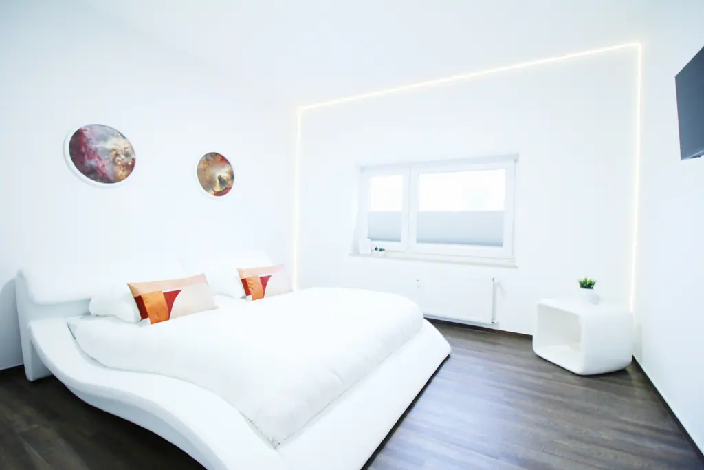 Schlafzimmer mit Planetenbildern und weißem Bett