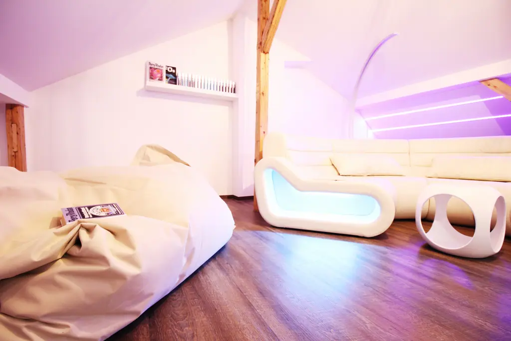 Sitzsack und Sofa im Dachgeschoss mit violettem Licht